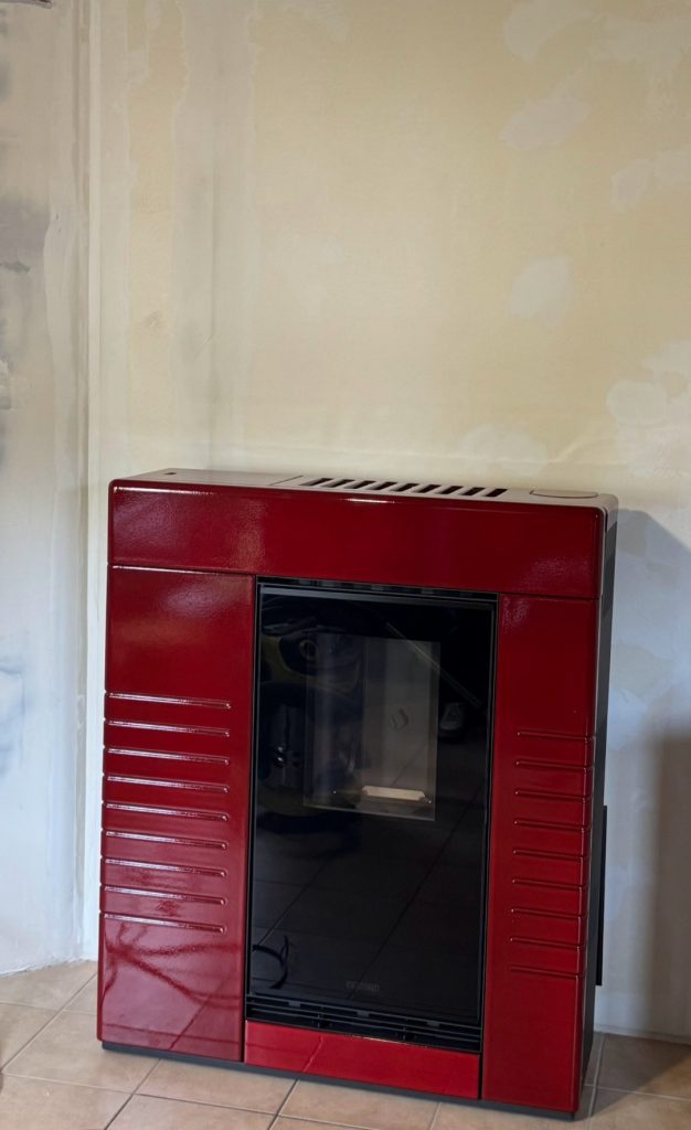 Installation d'un poêle à granulés Piazzetta réf : P 939 céramique Rouge Lave , à la place d'une cheminée , le conduit de fumé est installé dans un coffrage isolé